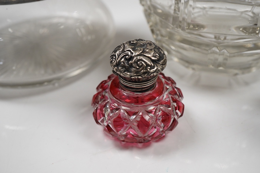 Two George V silver mounted glass powder jars, Henry Matthews, Birmingham, 1923, two silver mounted cut glass scent bottles including ruby flash and a white metal overlaid blue glass scent bottle.